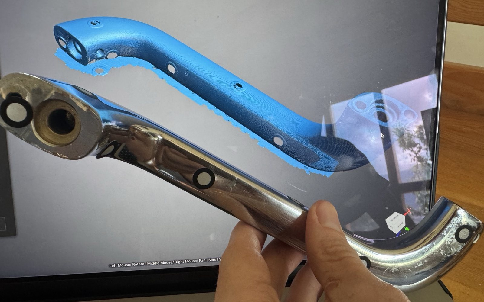 A chrome bathtub handle from Le Méridien Paro, held in front of its 3D scan
